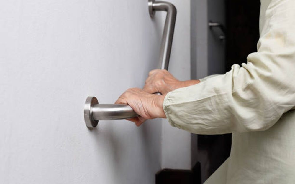 A hand holding a bathroom grab rail